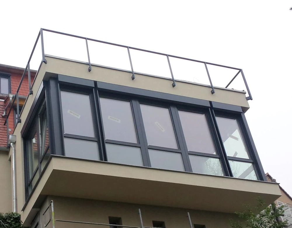Anthrazitfarbene Raffstoren an einer großflächig verglasten Fassade in Dresden