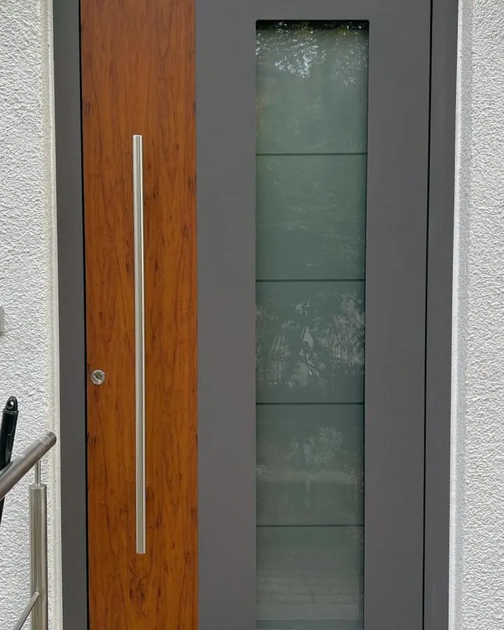 Montierte Aluminiumhaustür von Inotherm in Grau mit Holzdekor-Füllung und Glasausschnitt