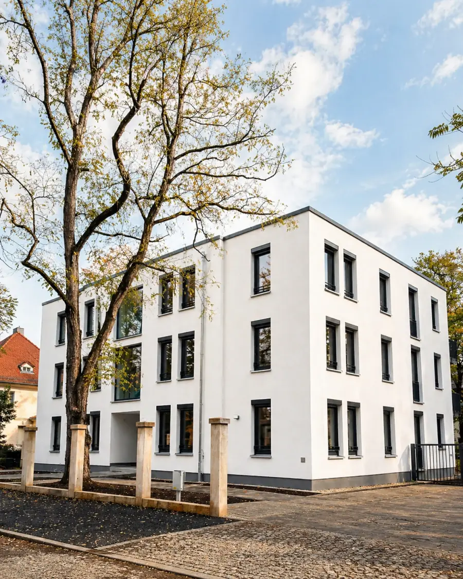 Modernes Wohngebäude mit großen dunklen Fensterrahmen und klarer Architektur in Dresden.
