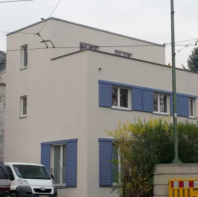 EHRET Schiebeladen JS-R75 in Taubenblau vor einer Hausfassade